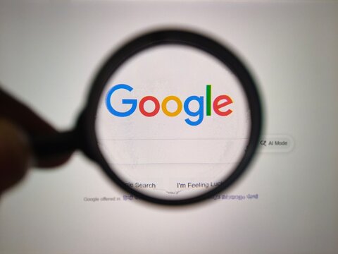 Google search page magnified through a magnifying glass