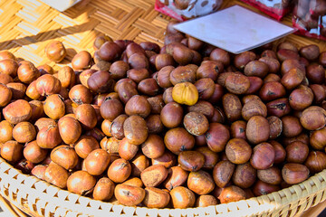 Close-up view of roasted chestnuts in woven bamboo basket