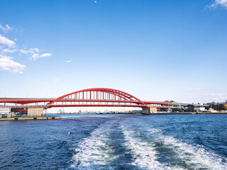 Obraz premium 神戸の絶景、青空に映える赤い大橋と航跡