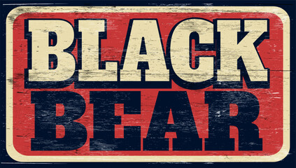 Aged and worn black bear sign on wood