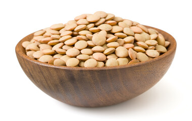 Uncooked brown lentils in the wooden bowl, isolated on white background.