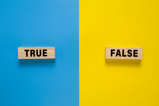 true and false on wooden blocks. isolated on blue and yellow background. copy space