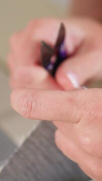 closeup hands trimming hangnail with clippers. Intimate home grooming scene, steady fingers and focused motion, visible skin texture and small torn nail edge, neutral background and clinical detail