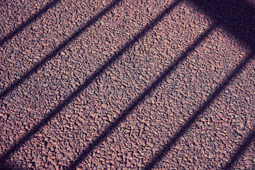 アスファルトに落ちた柵の影