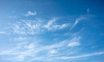 wide-angle landscape shot of a bright azure sky filled with delicate, streaky white clouds. This serene and airy image is perfect for nature backgrounds, weather themes, and peaceful designs.
