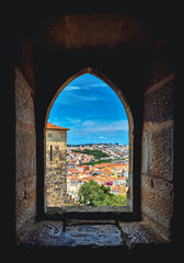 Fototapeta premium Panoramic city view framed by an ancient arch.