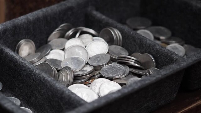 Sorting coins in two trays at a local market