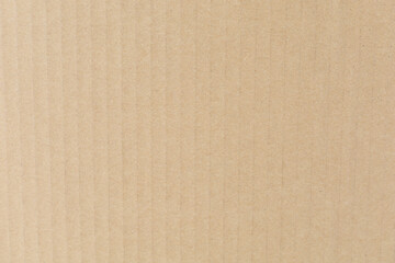 Close-up of textured beige corrugated cardboard surface, showcasing vertical ridges and subtle shading.