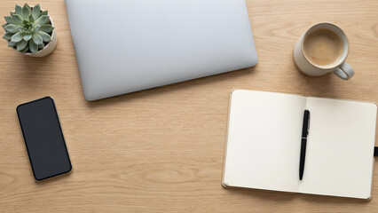 Minimal workspace desk with laptop, notebook, smartphone and coffee cup, top view