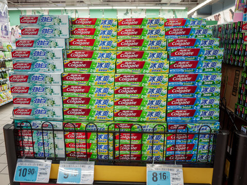 Retail display of Colgate toothpaste stacked in bulk packaging inside a supermarket in China. 
