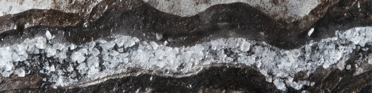Rough graphite mineral background with jagged ridges in Basil and Mint tones, featuring crystalline flakes and carbon deposits, ideal for industrial design and raw material quality concepts