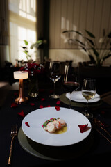 A romantic dinner table setting for a special occasion, with beautifully plated food and elegant glasses of wine. The atmosphere is inviting and intimate, perfect for a memorable dining experience.
