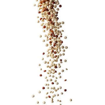 A dynamic stream of mixed tri-color quinoa seeds falling isolated on a white background.