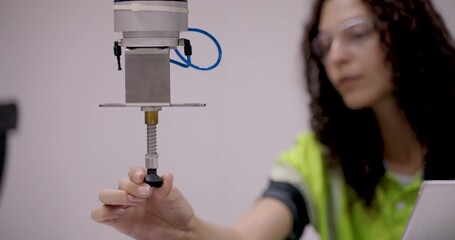 Collaborative robot lowers suction gripper near object as technician prepares to grab it by hand during advanced robotics training session focused on control, safety and precision handling