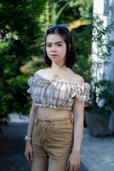 Cute Asian woman wearing glasses in a model-like style at a caf&eacute;