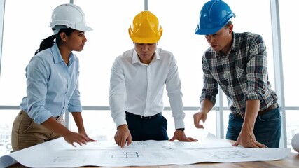 Three architects collaborating on a construction project plan.
