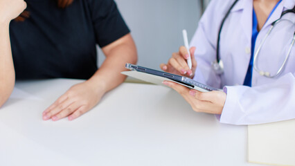 Close up asian female doctor sitting at desk consulting checking explaining patient in medical clinic hospital presenting results examination preventive care healthcare insurance services consultation