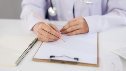 Close up hand of asian female doctor work in medical clinic hospital adviser collecting information writing prescription presenting results examination preventive care healthcare services consultation