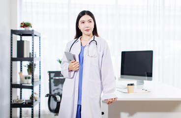 Portrait confident asian professional female doctor wearing white coat stethoscope standing holding tablet computer in clinic office hospital modern healthcare medical technology services consultation
