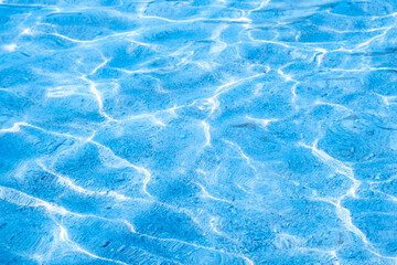 
Close-up of bright blue swimming pool water surface with sunlight reflections and ripples, refreshing summer vacation and tropical luxury background.concept relex