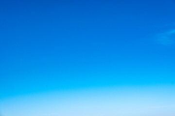 A bright, clear blue sky meets a glowing white horizon, suggesting a serene, open, and with sunlight of beautiful cloudy sky. landscape or abstract background