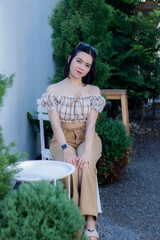 Cute Asian woman wearing glasses in a model-like style at a caf&eacute;