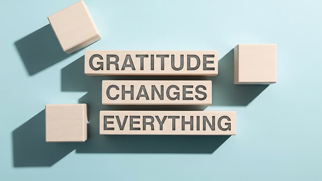 Gratitude changes everything wooden blocks with embossed letters spelling motivational quote about appreciation and positive outlook on life displayed on blue background