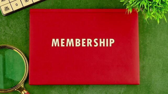 Close up shows red document folder on a green background. Letters are added to spell MEMBERSHIP. Letter tiles, plants, and a magnifying glass are also visible