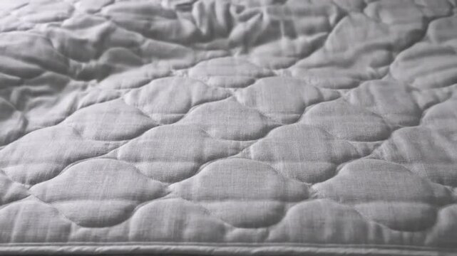 Abstract Close-up Texture of a Quilted Mattress Surface with Dynamic Light and Shadow Play