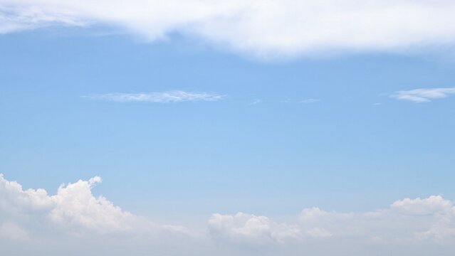 clear blue sky with soft white clouds background on a sunny day. Clean atmosphere with copy space