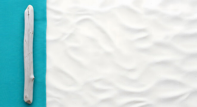 Driftwood log on white textured sand and turquoise striped beach