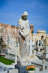 Obraz premium Elegant marble statue of a woman holding flowers in the Santa Maria Magdalena de Pazzis Cemetery in Old San Juan, Puerto Rico