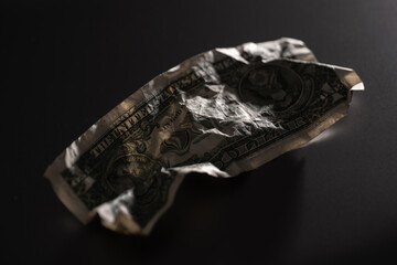 Crumpled one dollar bill  symbolizing poverty or financial hardship in the American economy