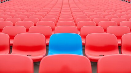 Fototapeta premium Blue Seat Amidst Red Individuality in the Crowd.