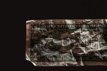 Crumpled one dollar bill  symbolizing poverty or financial hardship in the American economy