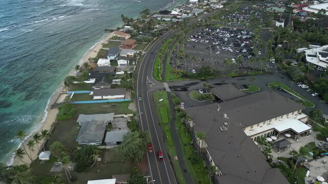 Descending Aerial View of Coastal Road and Residential Area in Laie Hawaii | Drone Shot of Oahu Shoreline Parking and Tropical Neighborhood
