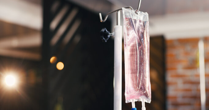 IV drip, bag or solution in clinic for healthcare, iron infusion or mineral treatment with flare. Bokeh, intravenous medicine or liquid in health center for vitamin therapy, antioxidants or hydration