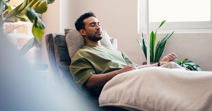 Infusion, relax and wellness with man in drip lounge for benefits of antioxidants, minerals or vitamins. Fluid, IV hydration and recovery with person in chair for healthcare or medical treatment