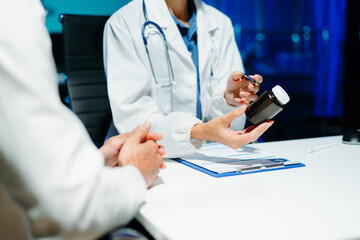 Closeup of doctor hands explaining a medicine bottle to a patient. Medical consultation, prescription guidance, healthcare, treatment,