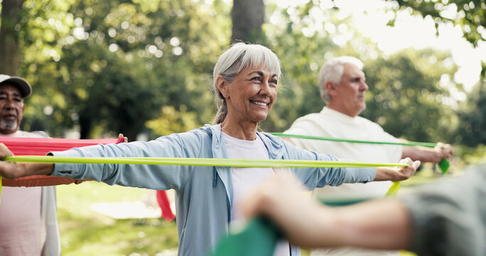 Fitness, resistance band and class with old woman in park for learning, mobility exercise and health club. Muscle warm up and wellness with senior people for low impact workout and instructor