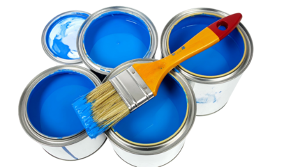 Open paint cans with bright blue pigment, a paintbrush rests across multiple