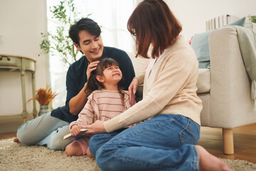 Asian parents share joyful family time with their little girl, showing happiness love and warm lifestyle indoors