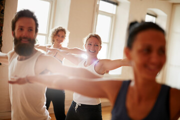 Yoga class, happy woman and exercise in studio for fitness, health and holistic wellness together. Group, yogi and people stretching for balance, warrior pose and hobby for pilates practice in club