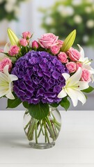 Obraz premium Elegant bouquet of pink roses, purple hydrangeas, and white lilies in a glass vase