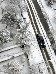 snow covered street with cars and trees after heavy snowfall, winter urban landscape from top view
