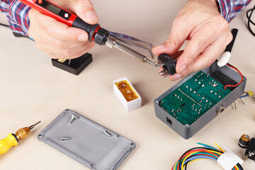 Soldering electrical board at service workplace.