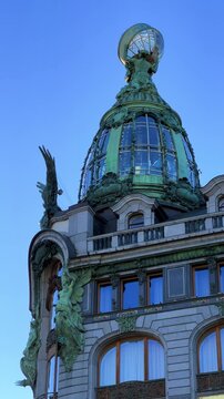 The Singer company's house in St. Petersburg on Nevsky Prospekt. A historic Art Nouveau building. Metal frame, bay windows and turrets decorated with sculptures of valkyries. A glass globe on the roof