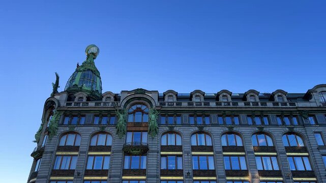 The Singer company's house in St. Petersburg on Nevsky Prospekt. A historic Art Nouveau building. Metal frame, bay windows and turrets decorated with sculptures of valkyries. A glass globe on the roof