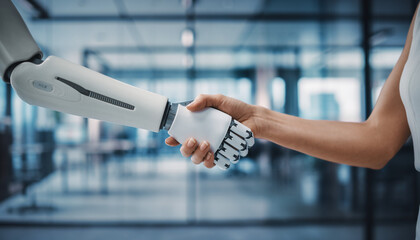 Human and humanoid robot shaking hands in modern office setting