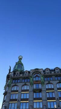 The Singer company's house in St. Petersburg on Nevsky Prospekt. A historic Art Nouveau building. Metal frame, bay windows and turrets decorated with sculptures of valkyries. A glass globe on the roof